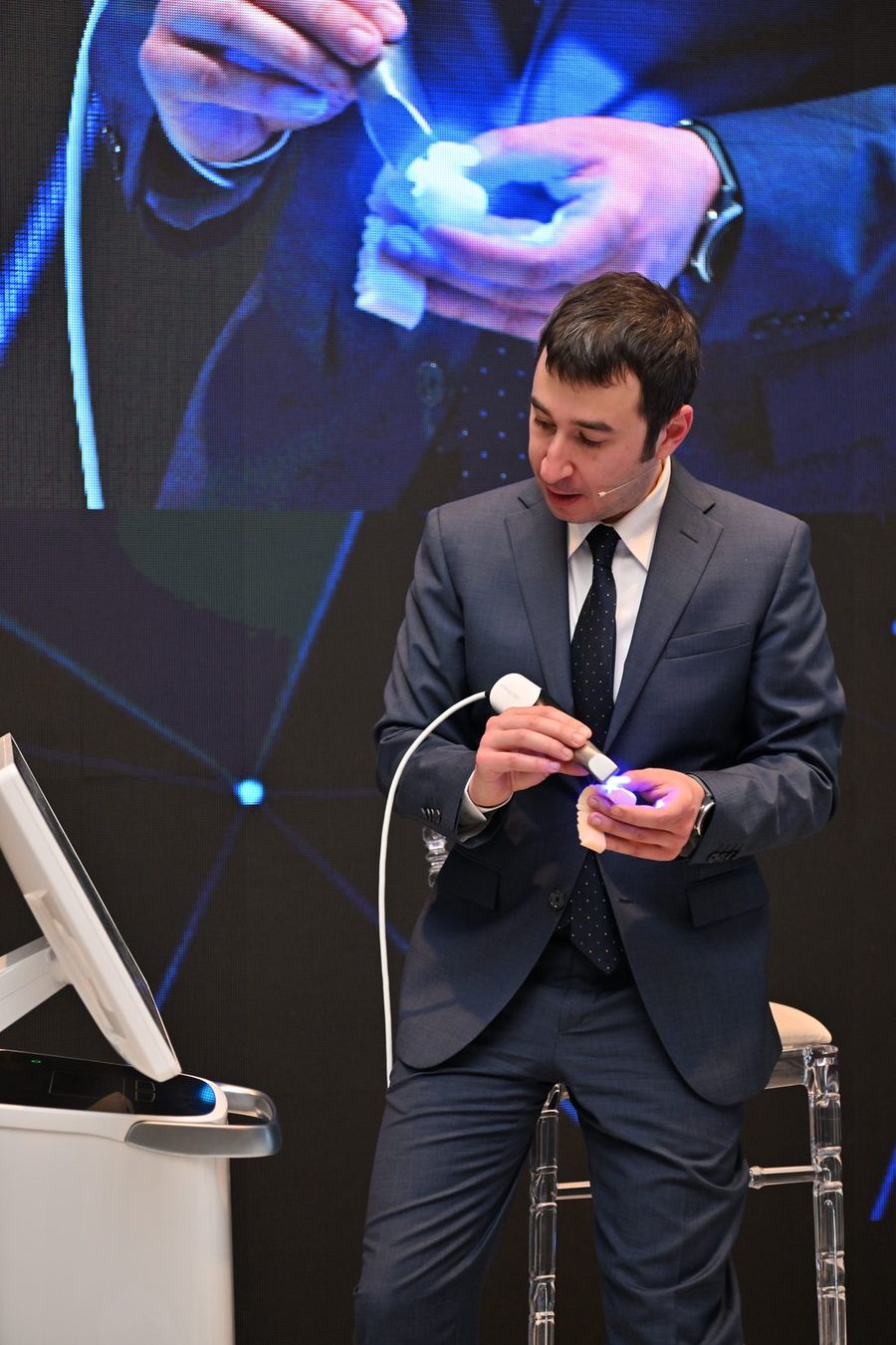 Dr. Dt. Mehmet Dikmen ağız içi tarayıcıyı model üzerinde gösterirken